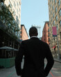 © Cultura Creative - Rear view of man in suit standing on street