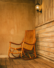 Vertical Shot Of A Wooden Rocking Chair On A Wooden Patio