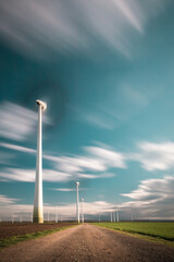 Canvas Print - Long exposure shot of windmills in the field and the cloudy sky in motion