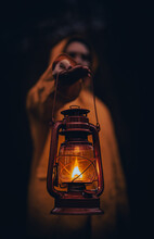 Vertical Shot Of A Young Man In A Yellow Hoodie Holding A Lantern