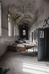 Wall Mural - Abandoned hospital building corridor with a hospital bed in the center of the corridor