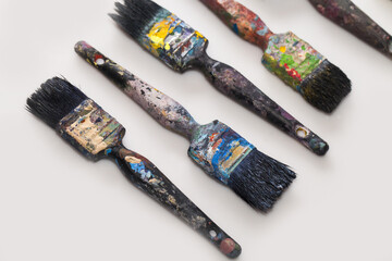 Poster - Old paint brushes with color stains on a white surface