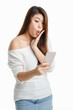 © Bangkok Click Studio - Studio shot Asian young surprised excited shocked female model in long sleeve shirt show naked shoulder standing open mouth hold hand on cheek looking at touchscreen smartphone on white background