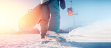 Back woman snowboarder stands with snowboard sun light, banner winter ski resort