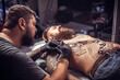© Mr. Prof - Tattooist makes a tattoo on the client's tattoo studio