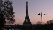 Paris, France. December 18. 2021. View of the Bir Hakeim bridge, tree and lampost off. Silhouette of Eiffel tower. Historic monument and passage of subway.