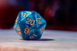 Close-up image of a blue role-playing gaming die with 20 sides