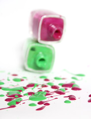 Wall Mural - Pink and Green Spilled Nail Polish on White Background