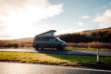 Beautiful shot of a big car moving on a road under a cloudy sky