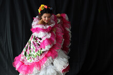 Portrait Of Young Colombian Girl Dancing
Wearing Traditional Folklore Sanjuanero Huilense 
Costume Dress In Pink And White With Flowers 