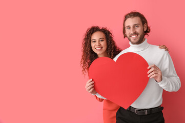 Poster - Happy young couple with red paper heart on color background. Valentine's Day celebration