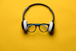© koldunova - Headphones and glasses look like a face on a yellow background. Musical concept. Top view.