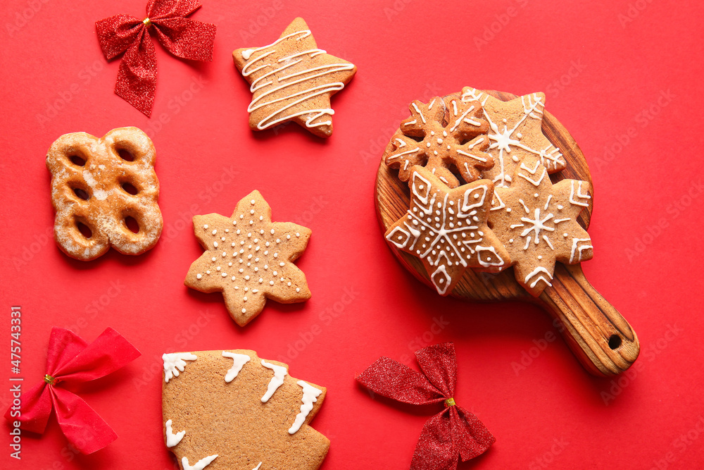 Composition with tasty gingerbread cookies and Christmas bows on red background