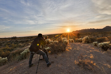 Photographer taking images of the sunset over mountains in Arizona