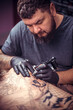 © Mr. Prof - Professional tattooer makes a tattoo on the skin in studio