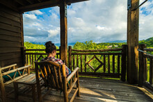 Woman Rests In Wooden Chair On Porch With Beautiful View Of The Great Smoky Mountains