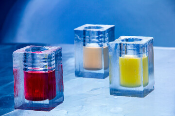 Canvas Print - Closeup shot of colorful drinks in ice glasses at an ice bar