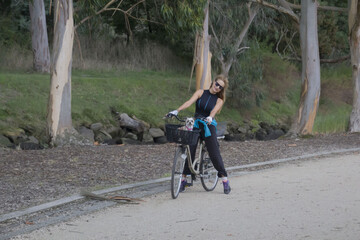 Sticker - Scenic shot of a beautiful Caucasian woman wearing sunglasses and driving a bike in Spain