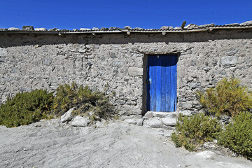 Wall Mural - Old barn of a house with a painted blue wooden door in the northern part of Chile