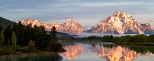 Panorama Shot Of Two Mountains Reflecting In The Water.