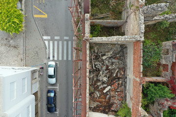 Poster - Aerial view of cars parked on a road beside old ruined buildings