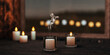 On a wooden table are scented candles in a glass, in the foreground there is a candle with a smoldering wick from which smoke comes.In the background is a window with reflected multi-colored lights 3D