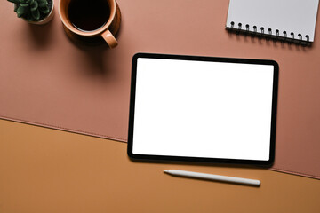 Poster - Top view image of a working desk surrounded by an empty screen digital tablet, potted of cactus, notebook and coffee cup