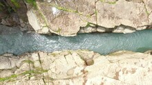 An Aerial View Of A Shallow River With Rocky Cliffs