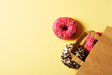 Some Pink And Chocolate Donuts With Paper Package