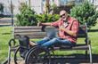 © romaset - Freelancer with a physical disability who uses wheelchair working at the park