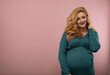 © rubchikova - Pregnant woman in green dress speaks by phone