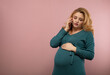 © rubchikova - Pregnant woman in green dress speaks by phone