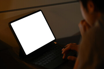 Poster - Photo of a freelance man using a white blank screen digital tablet in the bedroom.