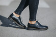 Legs of a female wearing fashionable black loafers