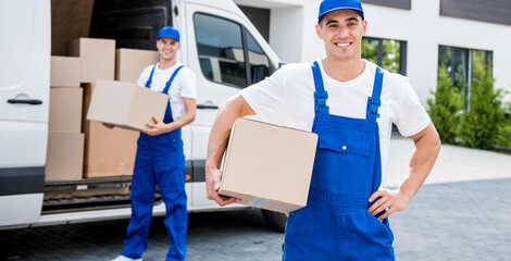 Wall Mural - Two removal company workers unloading boxes from minibus into new home