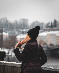 Poster - Selective focus shot of a redhead woman wearing a beanie from her back on a bridge in Prague