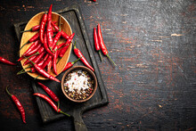 Red Chili Pepper Pods On A Cutting Board. On A Rustic Dark Background. High Quality Photo