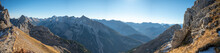 Panoramic Beautiful Scene Of The Rocky Karwendel Snowy Mountain With A Blue Sky On A Sunny Day