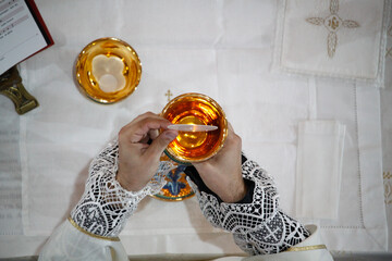 Wall Mural - A priest celebrates a mass and consecrates wine and bread 