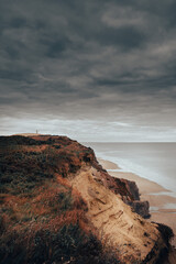 Sticker - Vertical shot of cliff near the seashore under a gloomy sky