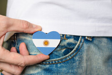 Patriot Of The Argentina! Wooden Badge With Argentina Flag In The Shape Of A Heart In A Man's Hand.