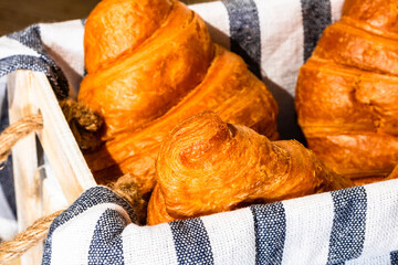 Wall Mural - Closeup shot of French croissants in a wooden crate