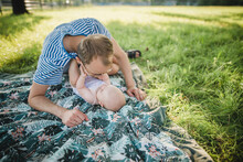 Father And A Baby Playing On A Grass