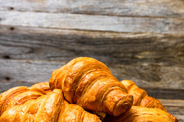 Sticker - Delicious, fresh croissants are isolated on wooden board. French breakfast concept.