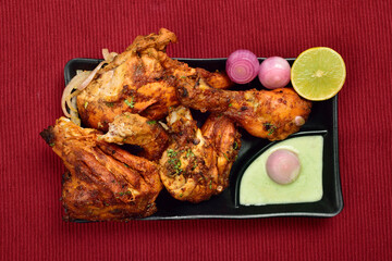 Wall Mural - Top View of Tandoori Chicken with Onion Chutney and Lemon in Plate, Famous Indian Food Tandoori Murg