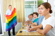 School teacher with flag explains to students what is LGBT in schoolroom