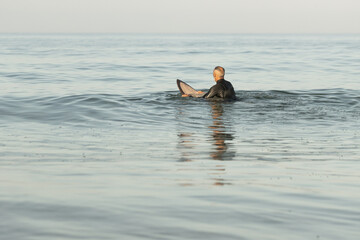 Canvas Print - Mature male in a wetsuit with a surfing board