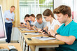 © JackF - Pupils sitting in class room and watching in their smartphones.