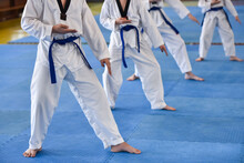 Taekwondo Kids. Boys Athletes In Taekwondo Uniforms With Blue Belts During A Taekwondo Tournament