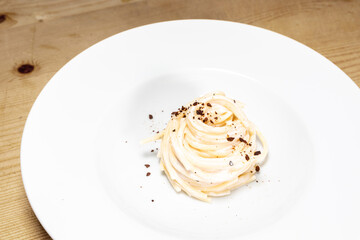 Canvas Print - Closeup shot of a delisous vegan pasta dish on a white plate on a tabl